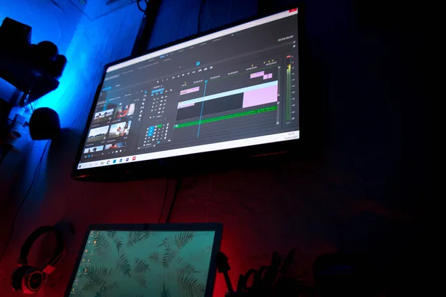 A dark room with computer screens displaying video editing software, creating a moody atmosphere. 5 things to check in Youtube channel software