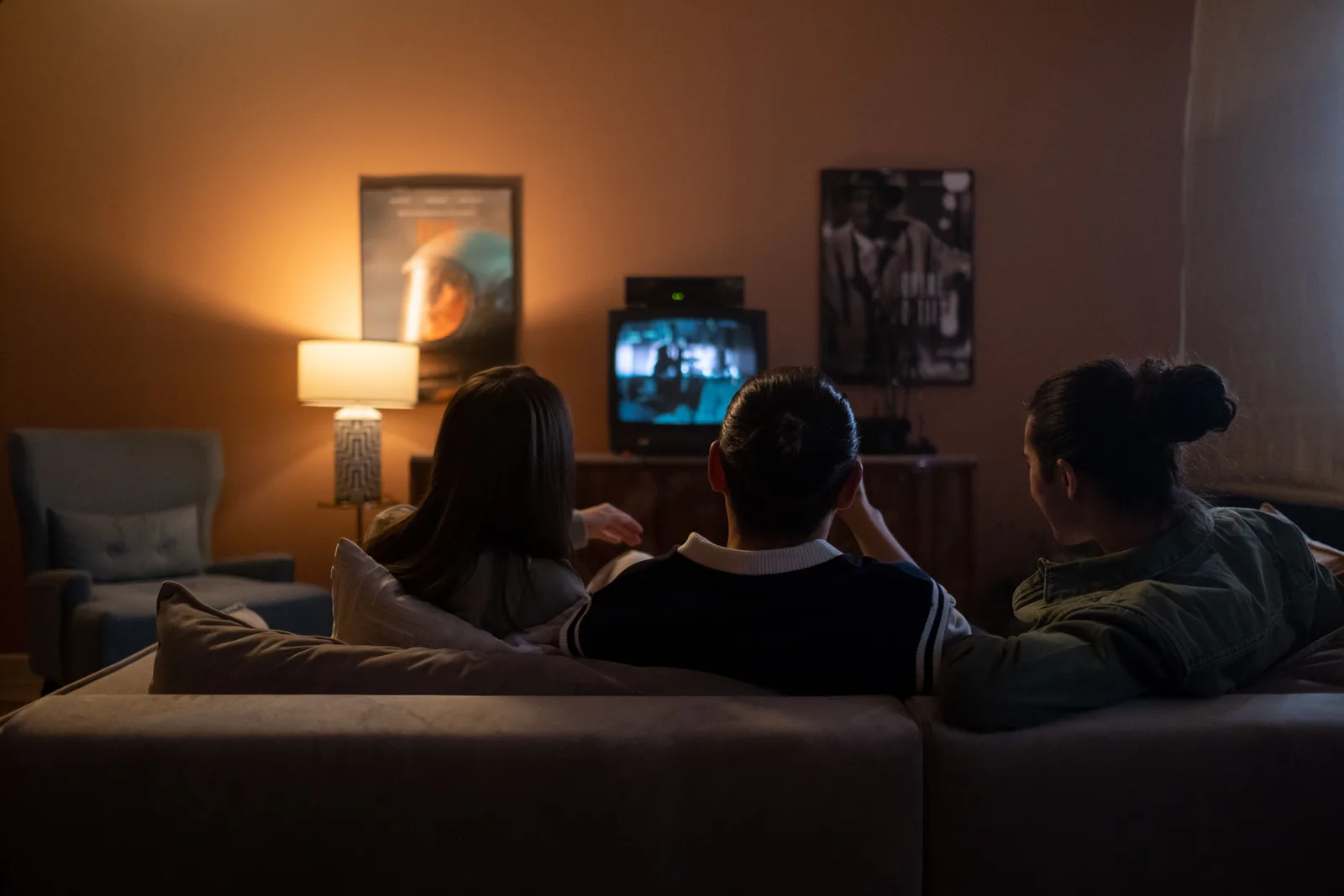 Three people enjoying a relaxed movie night at home, sitting on a couch in a cozy living room. 3 things to understand about Youtube channel trends